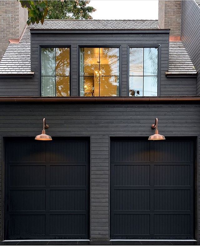 The Ultimate Style Statement: Black Painted House with Horizontal Wood Piece Over Garage Doors