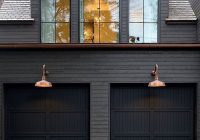 The Ultimate Style Statement: Black Painted House with Horizontal Wood Piece Over Garage Doors